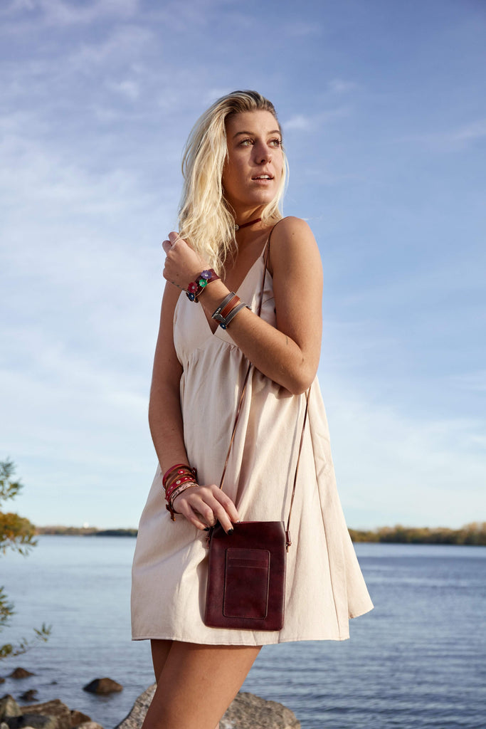Model carrying Ready to Go Crossbody from Most Wanted USA by the shore